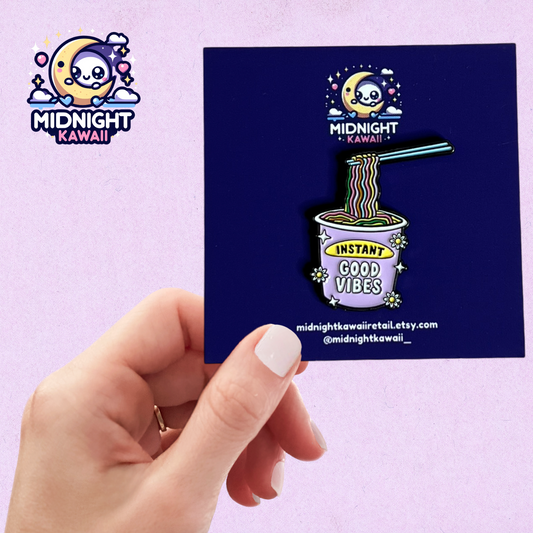 An enamel pin of an instant ramen cup with rainbow noodles and the words "INSTANT GOOD VIBES" in pastel purple, yellow, pink and blue on a dark background, in the style of a cartoon. Size 3-4cm. The pin has a securing arrangement on the back to enable attachment to clothes, bags etc.