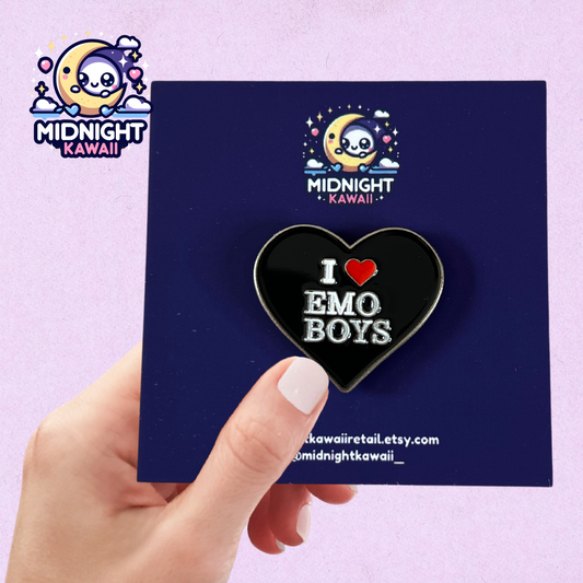 Black heart shaped enamel pin with the words "I LOVE EMO BOYS" engraved. The "LOVE" is in fact a red heart, rather than word "LOVE". Size 3-4cm. The pin has a securing arrangement on the back to enable attachment to clothes, bags etc.